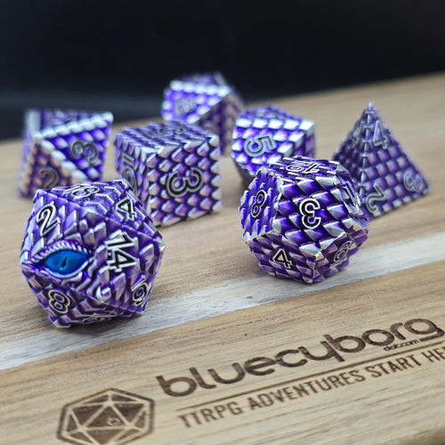 Purple and silver dragon scale metal RPG dice with a blue dragon eye