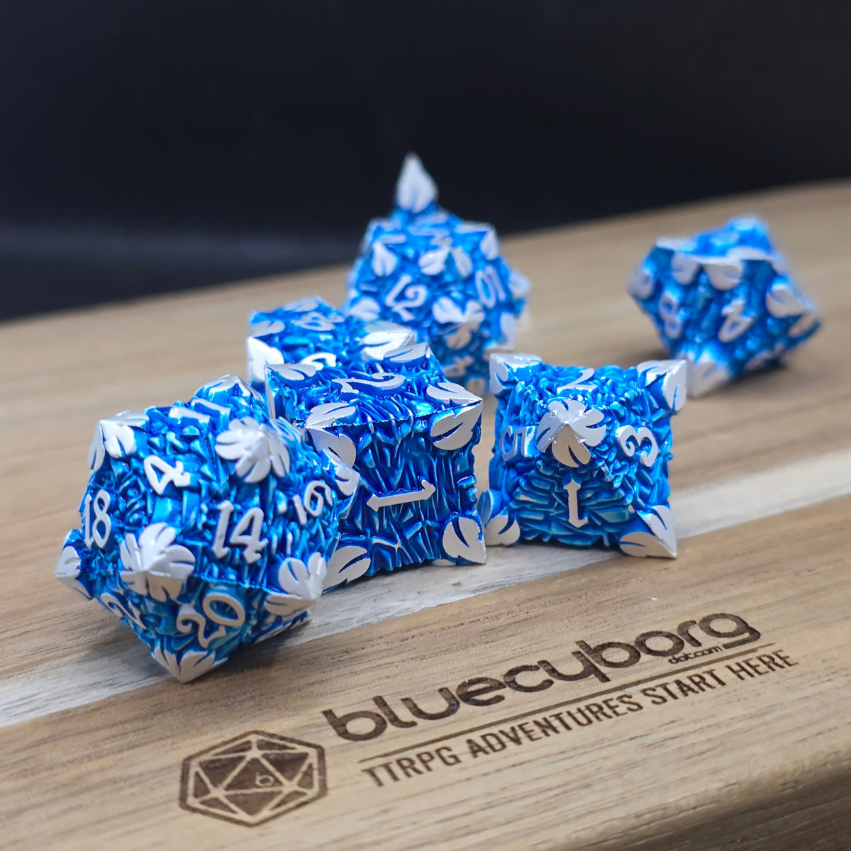 Blue metal RPG dice set with silver numbers and sculpted detailing