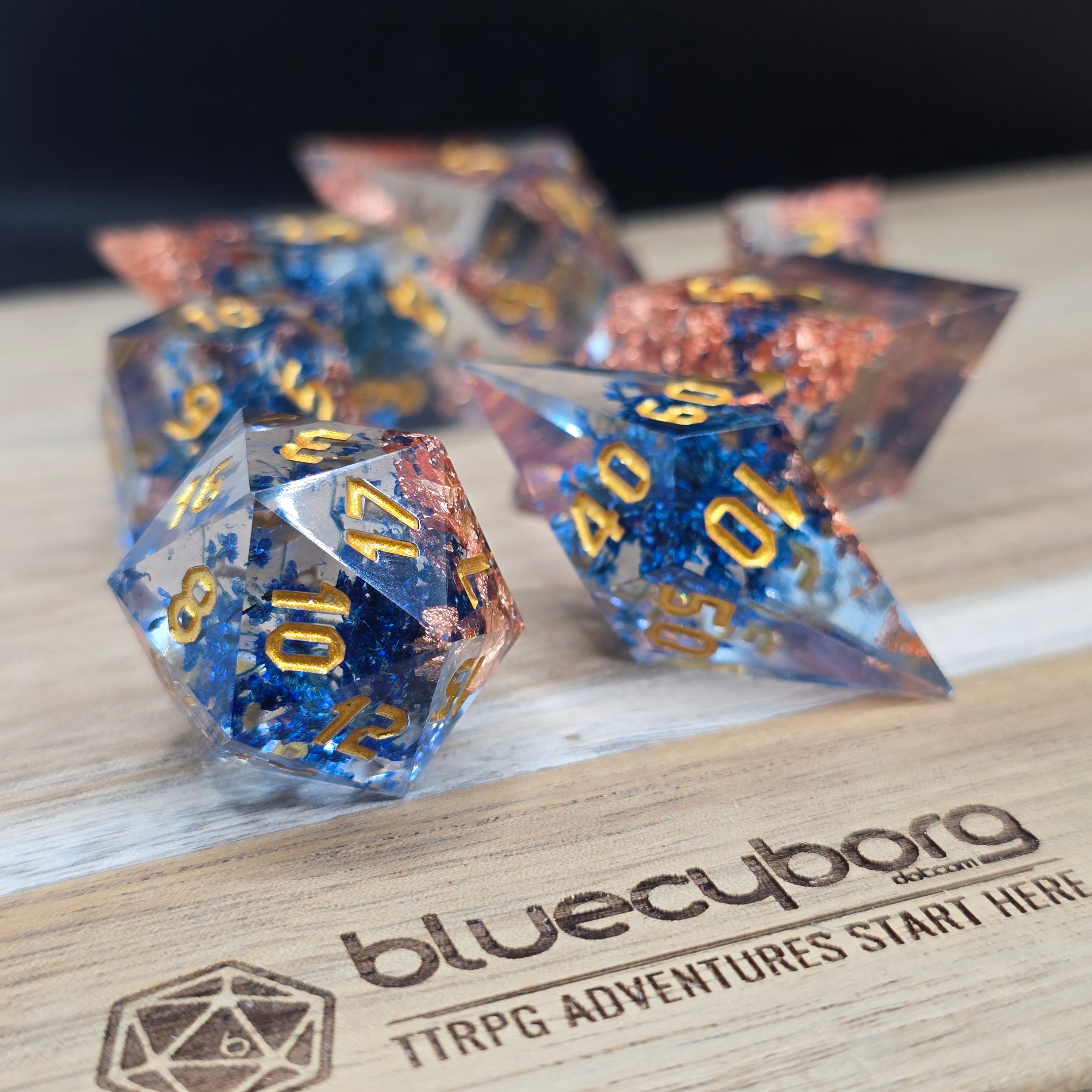 Copperbloom clear resin dice set with blue inclusions, copper foil and unusual dice shapes