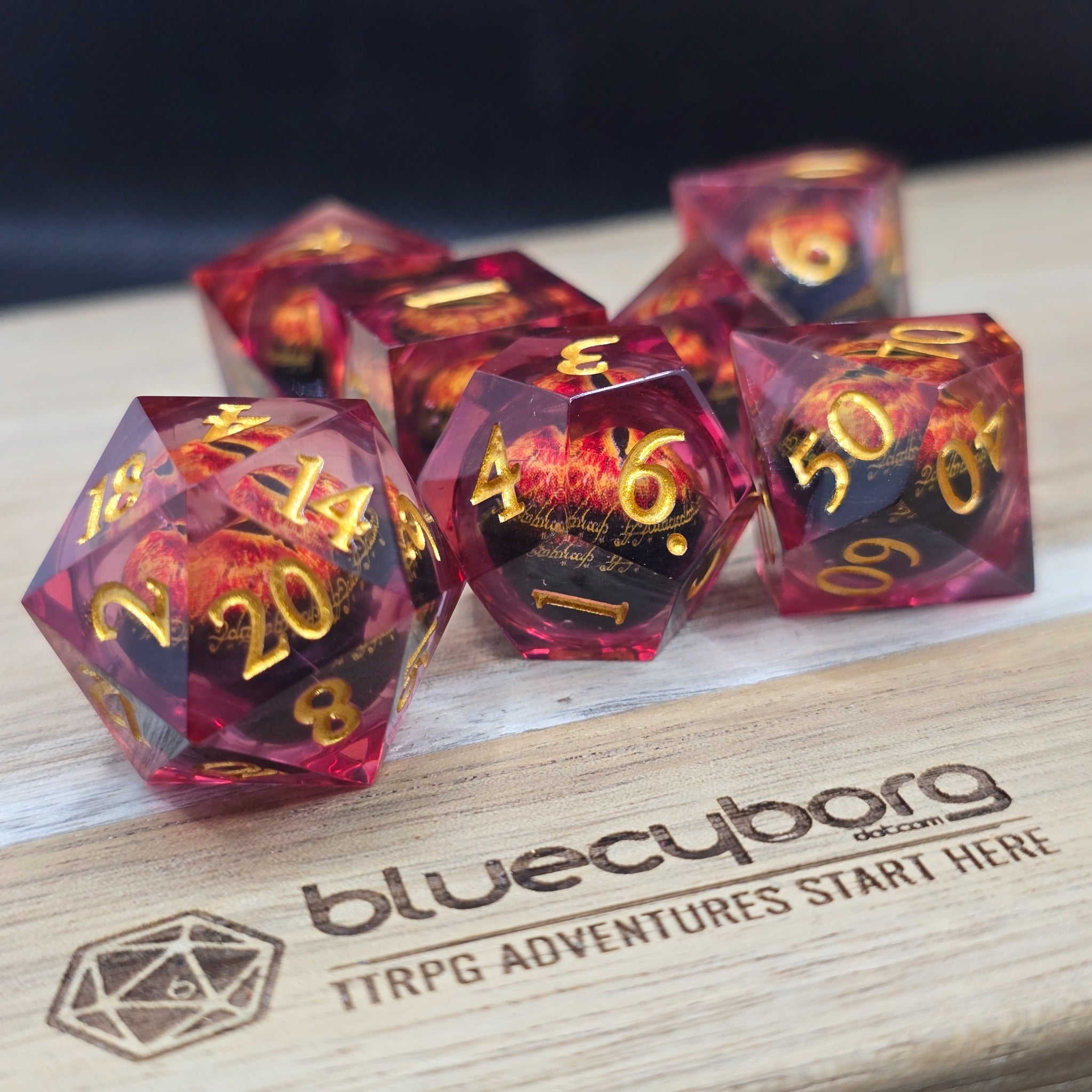 Dragon Eye Crimson Gaze moving eye liquid core resin dice set with crimson resin, gold numbers and fiery dragon eye design