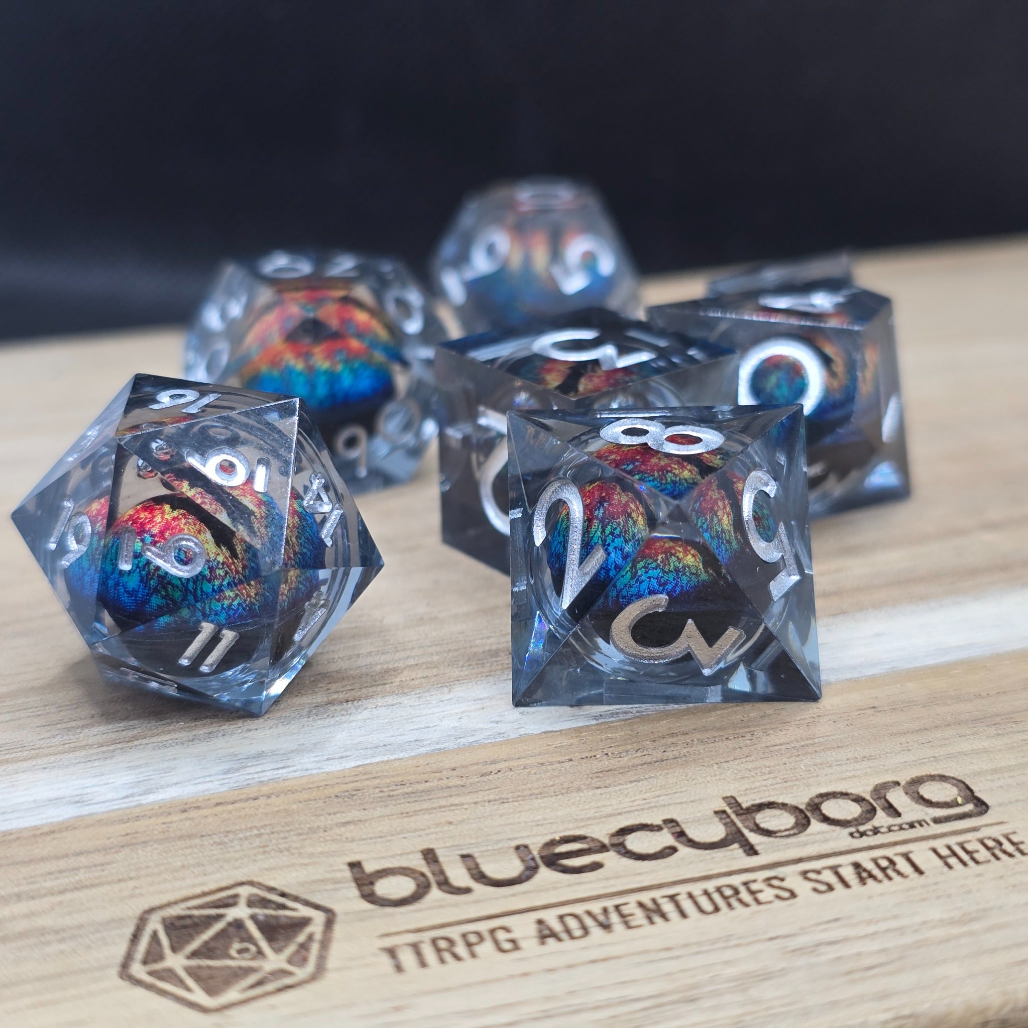 Dragon Eye Prismatic Gaze liquid core resin dice set with smoky clear resin, silver numbers and multicolour dragon eye cores