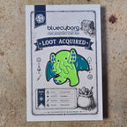 Eldritch Stomp enamel pin badge on BlueCyborg loot card
