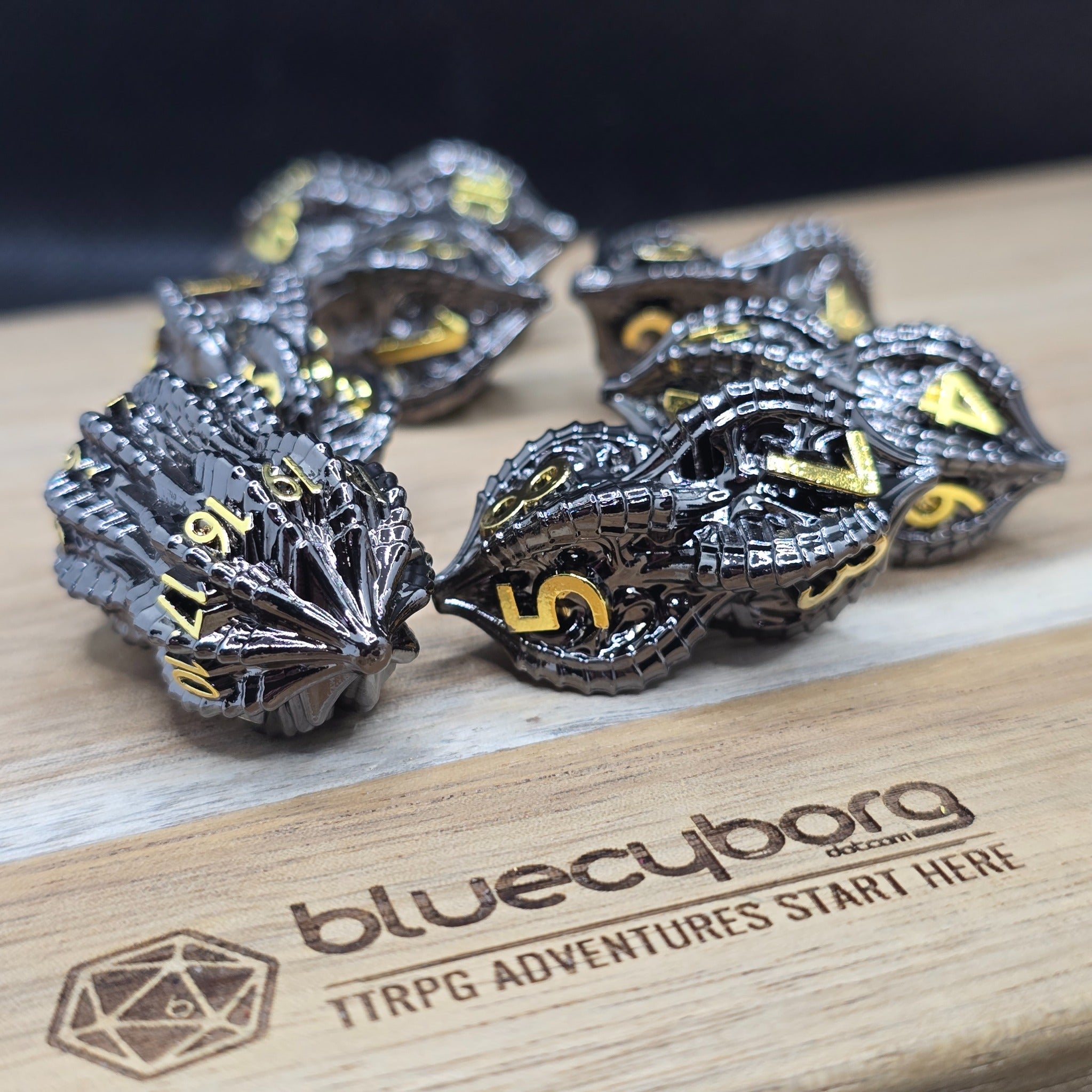 Goblin Peanut Black Gold metal dice set with unusual split-shell shape, gunmetal finish and gold numbers