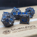 Joker’s Gambit Blue Steel metal dice set with gunmetal frame, blue panels, playing card details and joker face