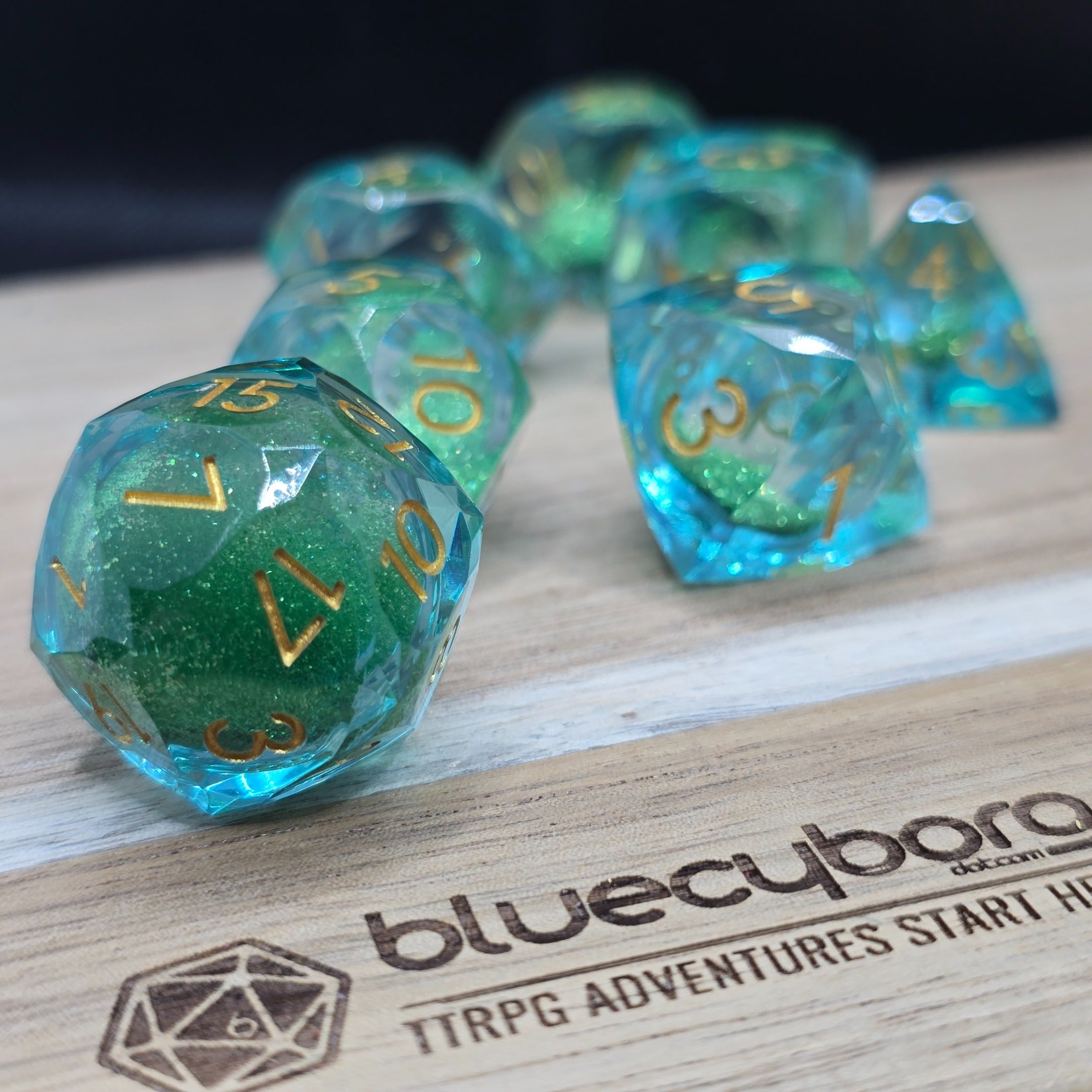 Ocean Glass Emerald Jewellers Cut liquid core resin dice set with blue green resin and gold numbers