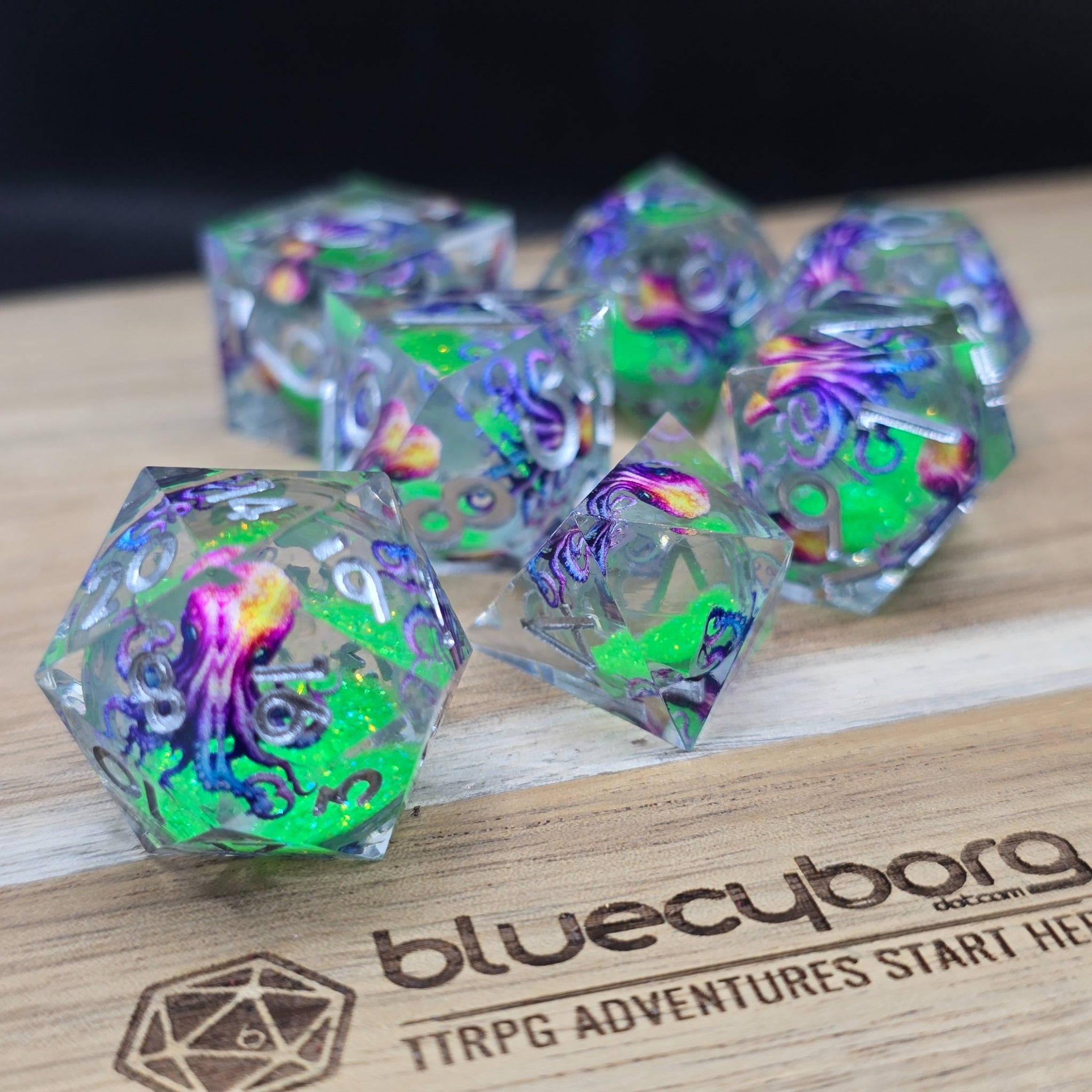 Prismatic Kraken liquid core resin dice set with multicoloured octopus and green glitter core