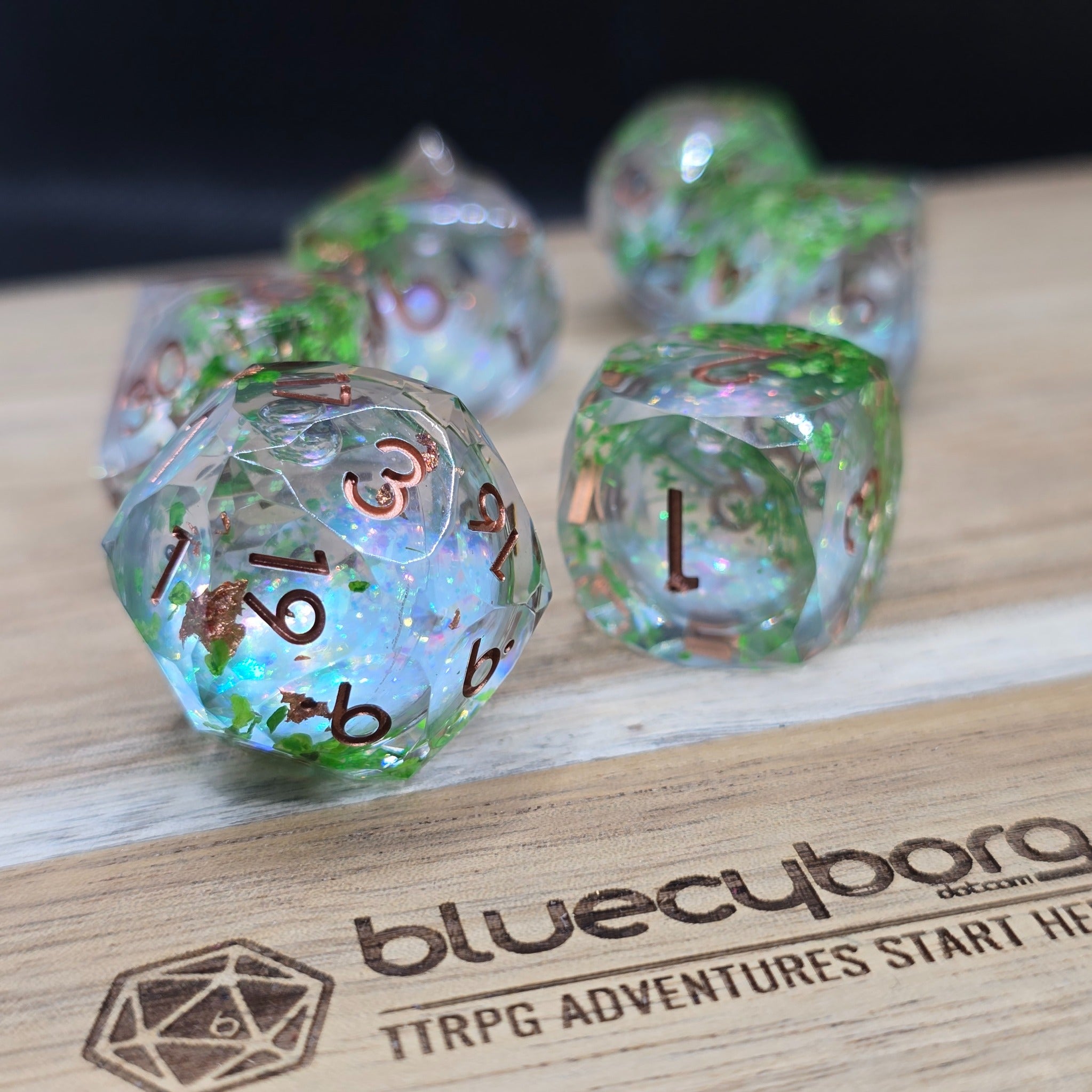 Verdant Blossom Jeweller’s Cut liquid core resin dice set with green foliage, pink shimmer glitter and copper numbers